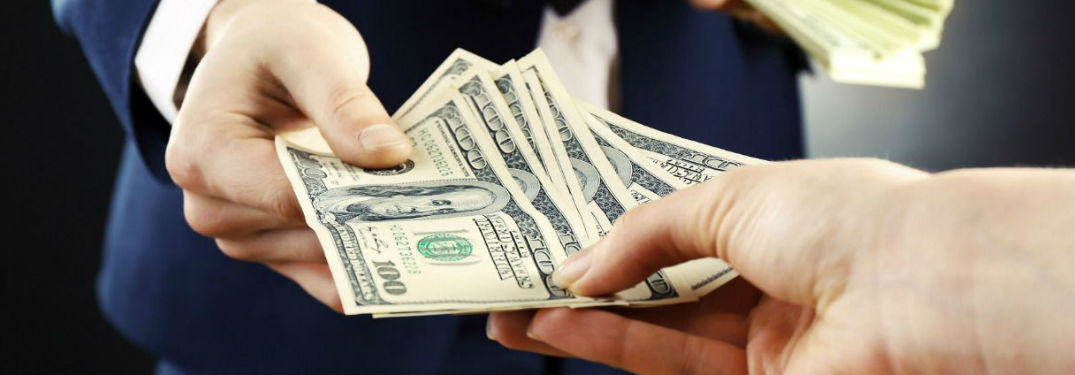 Someone handing money to another person