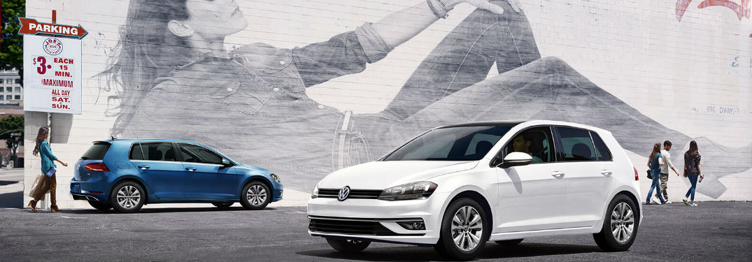 Two Volkswagen Golf cars parked by each other