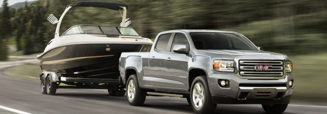 GMC Canyon towing a boat on a road
