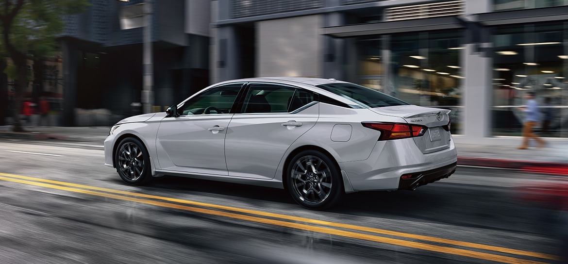 Silver Nissan Altima driving through a city